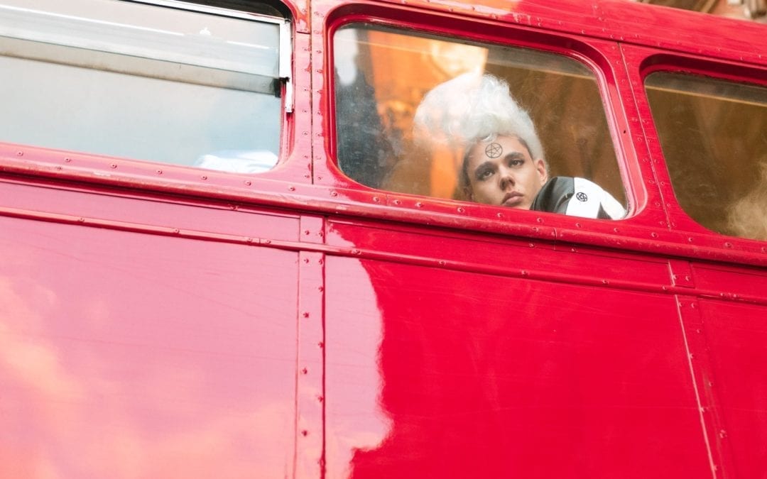 Person looking out through the window of a Red Routemaster Bus
