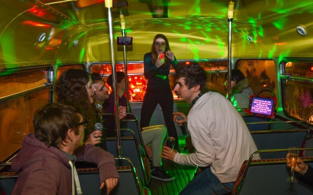 People enjoying karaoke in a redroutemaster.com bus